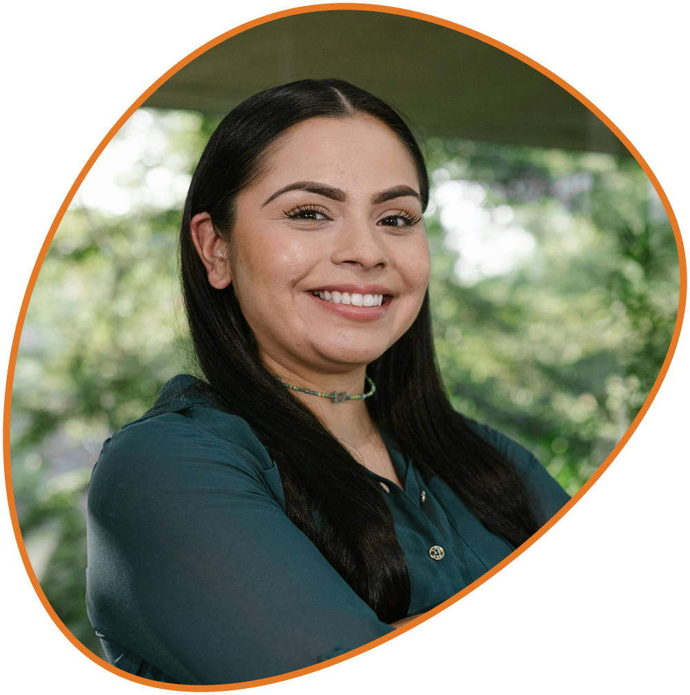 Neuroscience Smiling female team member with long dark hair wearing a teal blouse.